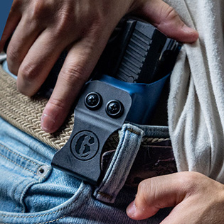An image of a man reaching for his IWB Kydex Holster preparing to draw.