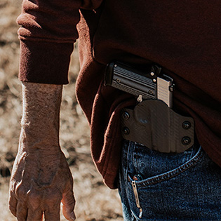 A man with a holstered firearm on a minimalist holster.