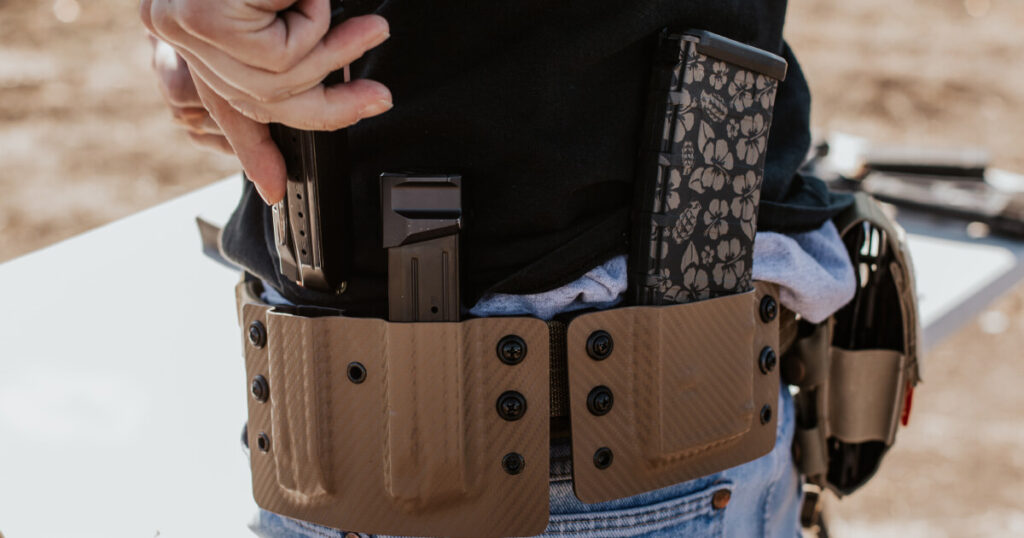 An image of a man using his Double Magazine Holster at the practicing shooting range.