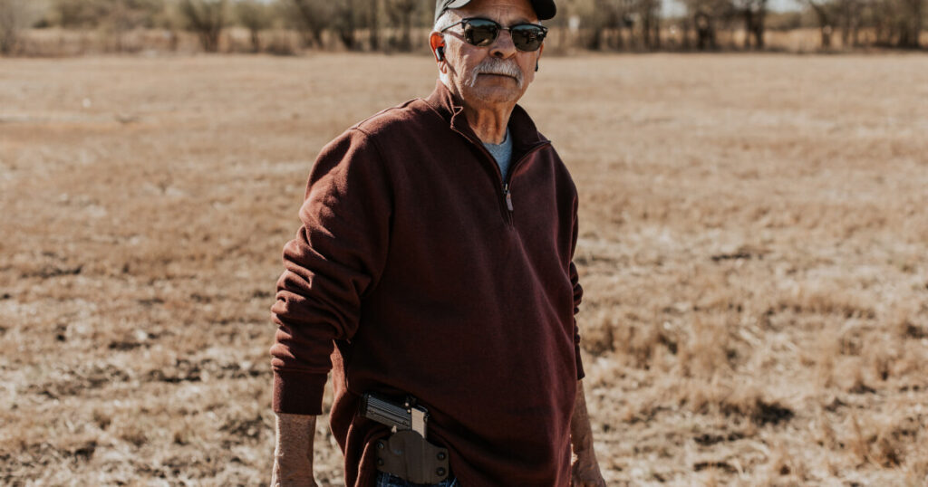 An image of a man at a practicing shooting range showcasing his minimalist gun holster.